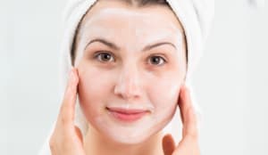 woman moisturising face